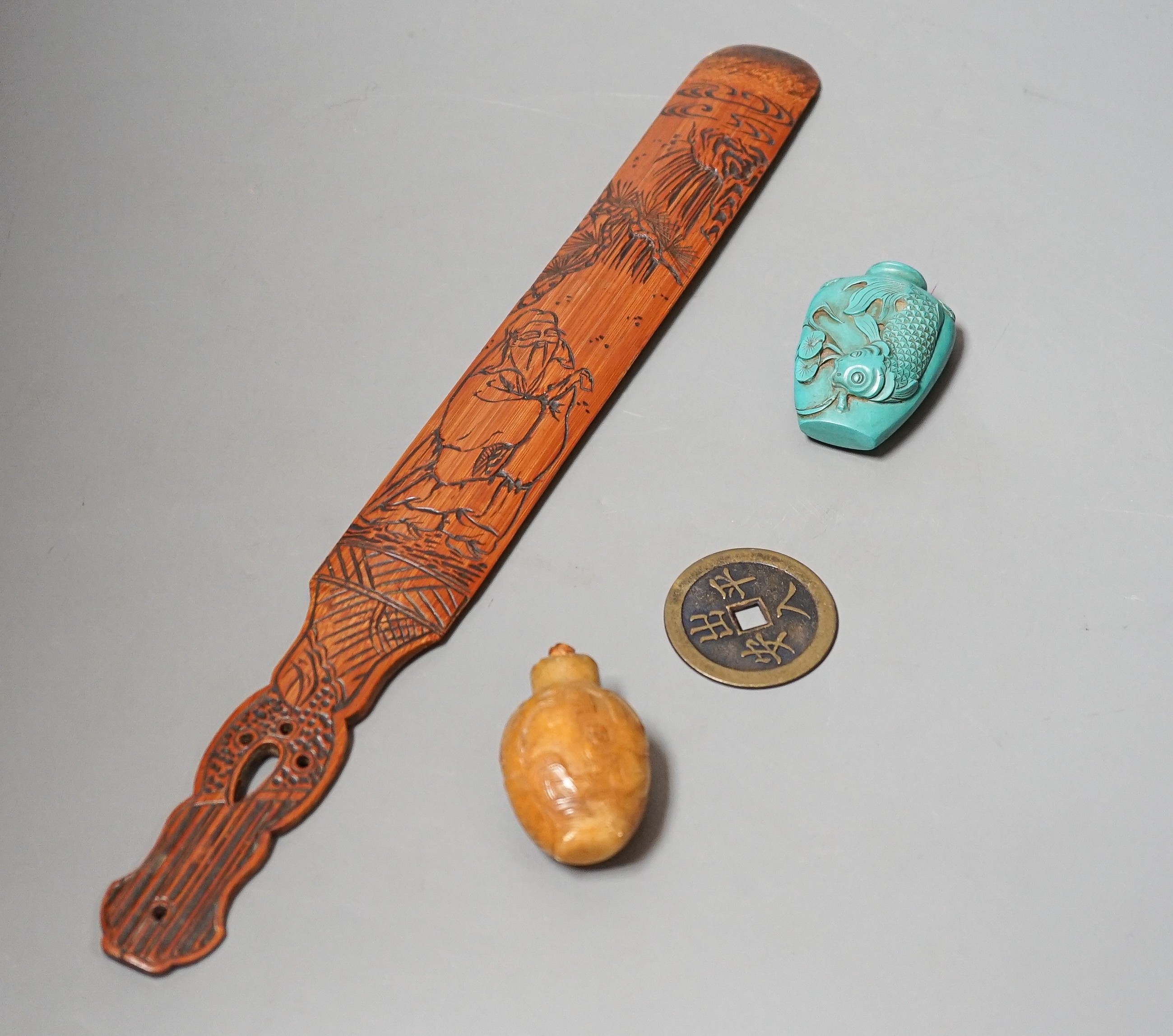 A Chinese soapstone snuff bottle, another snuff bottle, a bamboo page turner, 40cm and a brass amulet